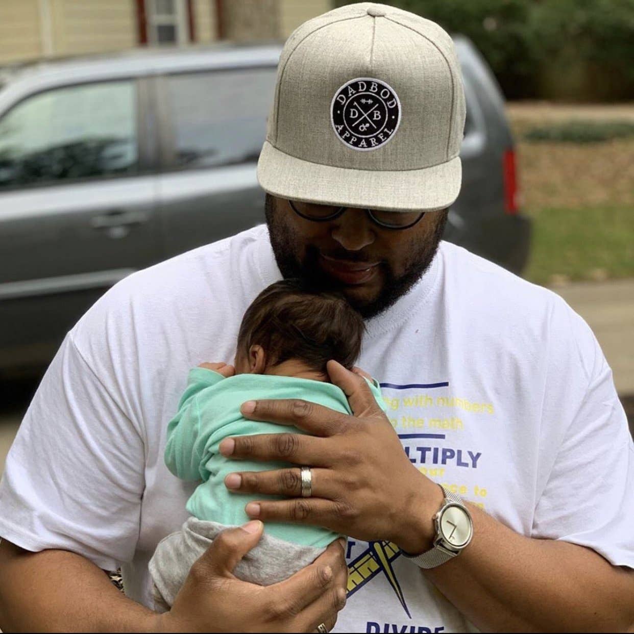 Man holding a baby in a casual outdoor setting