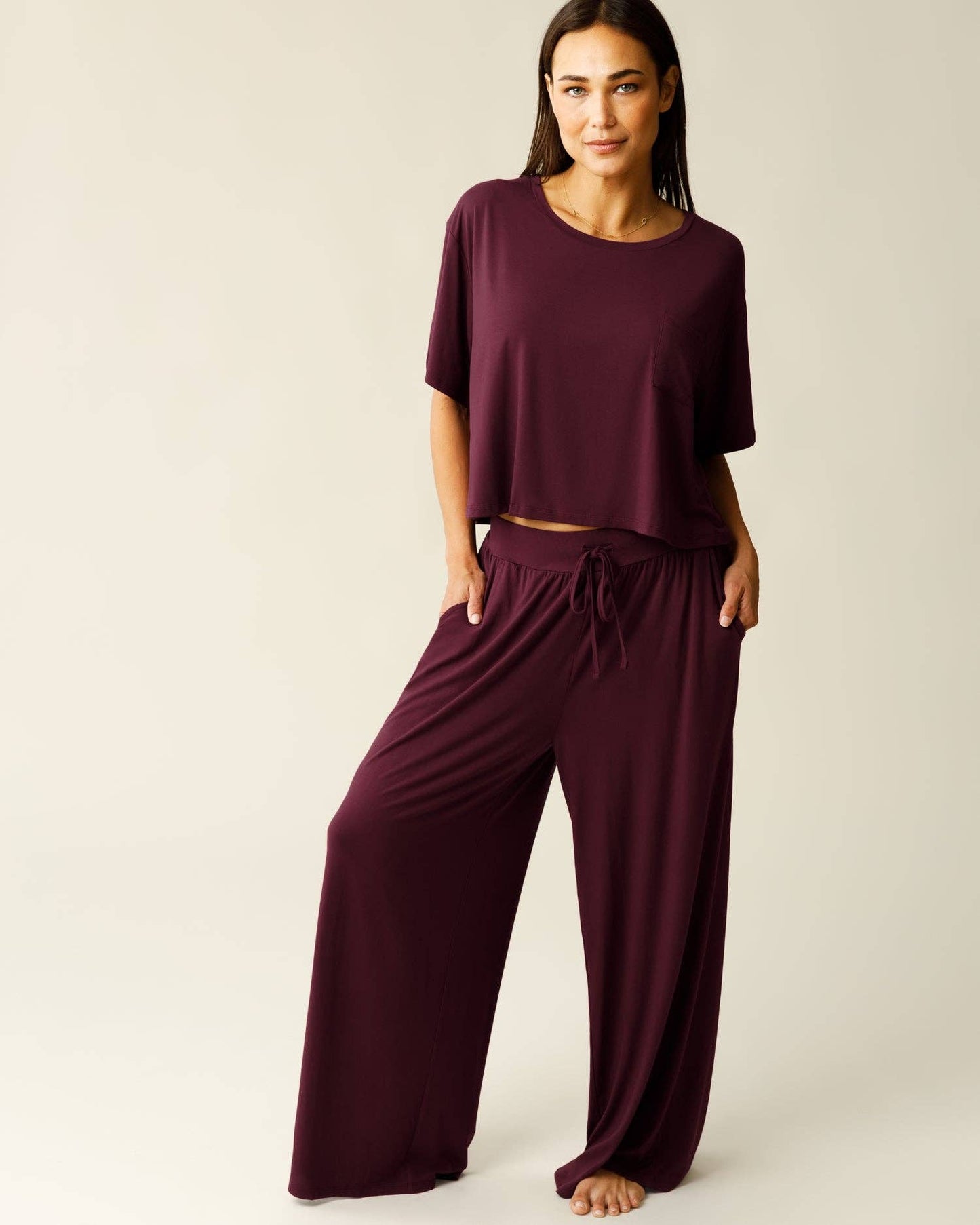Woman wearing a burgundy lounge outfit on a plain background