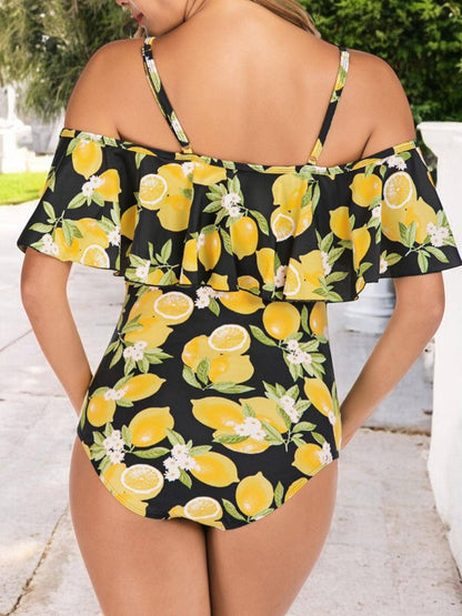 Woman wearing a black swimsuit with yellow lemon print outdoors.