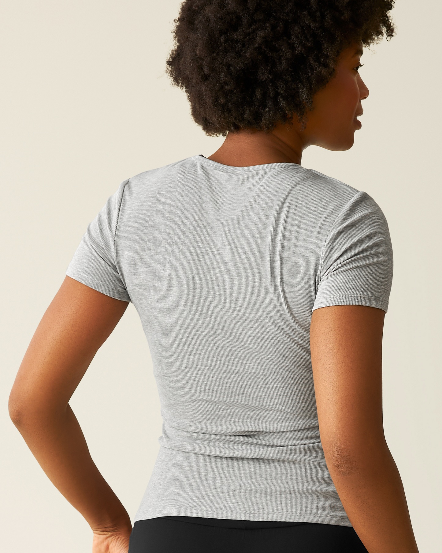 Woman wearing a gray t-shirt against a neutral background