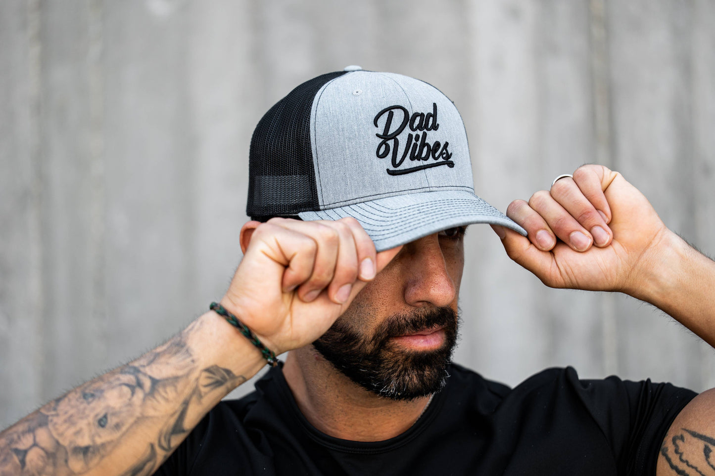 Man wearing a cap with 'Dad Vibes' text against a neutral background