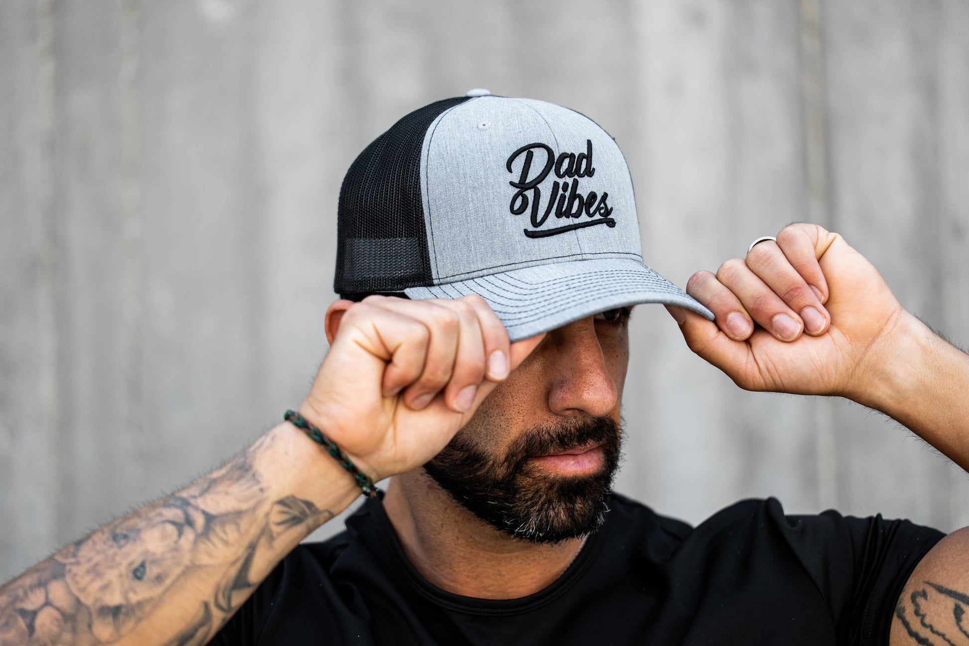 Man wearing a cap with 'Dad Vibes' text against a neutral background