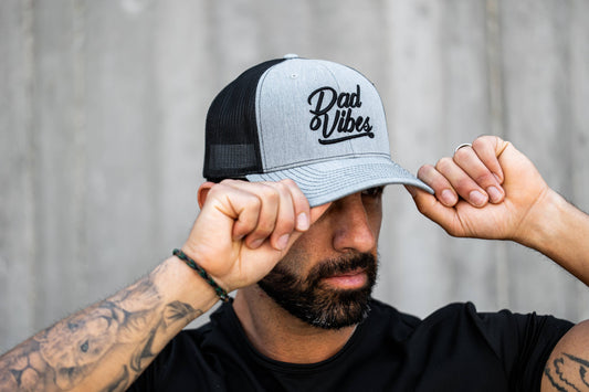 Man wearing a cap with 'Dad Vibes' text against a neutral background