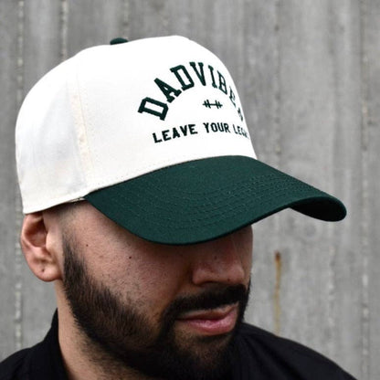 Man wearing a white and green cap with 'DADVIBES' text against a gray background