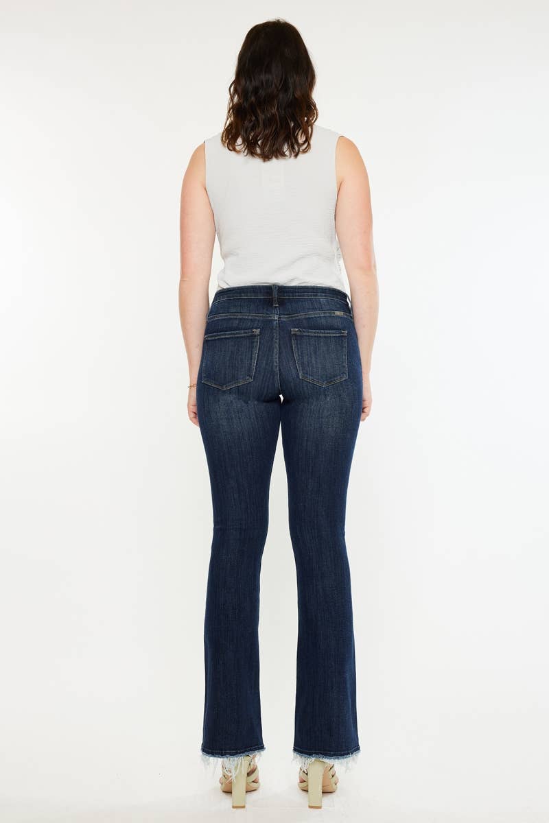 Pregnant woman wearing dark blue jeans and a white top on a white background